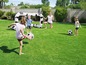 Kinder spielen Fußball mit einem aufblasbaren Tor im Garten.
