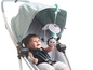 Ein Baby in einem Kinderwagen mit einem Tiny Love Spielzeugmobil.