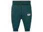 Grüne Jogginghose für Babys mit 'New In The Hood' Label.
