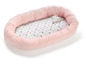 Ein rosa Nestchen für Babys mit Punkten und einem Eulen-Spielzeug.
