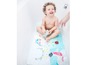 Ein Baby spielt in der Badewanne mit einer Badematte und Spielzeug.