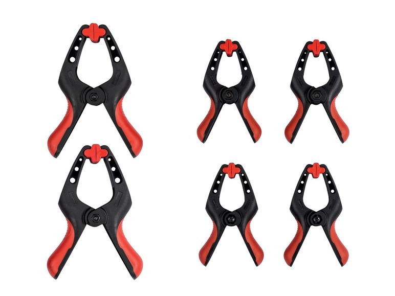 Sechs schwarze Klemmen mit roten Griffen.