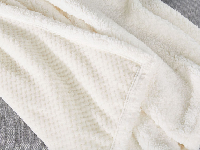 Eine weiche, weiße Decke mit einer flauschigen Textur.