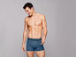 Mann in blauen Boxershorts mit Muster.