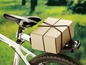 Ein Paket auf einem Fahrradgepäckträger mit Gummibändern.