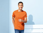 Mann in einem orangefarbenen T-Shirt und blauen Jeans.