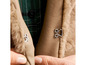 Detail einer braunen Lederjacke mit Pelzkragen und Knopfverschluss.