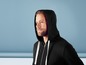 Mann trägt einen schwarzen Hoodie mit weißen Kordeln.