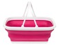 Ein rosa faltbarer Wäschekorb mit weißen Griffen.