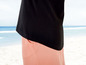 Schwarzes T-Shirt und rosa Hose am Strand.