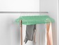 Mintgrüne Kleiderbügel mit Kleidung in einem Schrank
