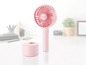 Ein rosa Unold tragbarer Ventilator mit Ladestation.