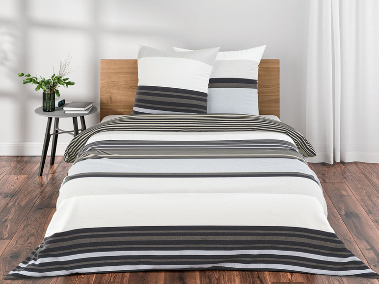 Ein weißer Bettbezug mit schwarzen und beigefarbenen Streifen.