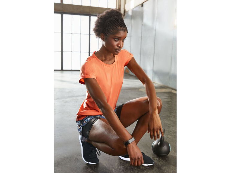 Frau in Sportkleidung mit einer Kettlebell beim Training.