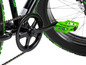 Nahaufnahme eines schwarzen Fahrrads mit grünen Pedalen und einer Kette.