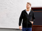 Mann in einem schwarzen Kapuzenpullover mit Reißverschluss.