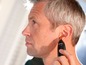 Ein Mann verwendet einen Philips Series 5000 Trimmer zum Trimmen seiner Ohrhaare.