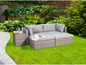 Rattan-Lounge-Set mit grauen Kissen und Beistelltisch im Garten.