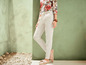 Weiße Leinenhose mit Blusen-Oberteil mit Blumenmuster.