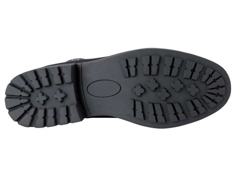 Die Sohle eines schwarzen Lederschuhs mit grobem Profil.