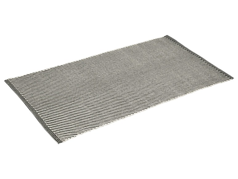 Schwarz-weiß gestreifter Teppich mit Fransen.