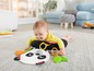 Ein Baby, das auf einer pandaförmigen Spielmatte mit Beißringen liegt.