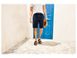 Mann mit blauen Shorts, weißem Shirt und Sandalen.