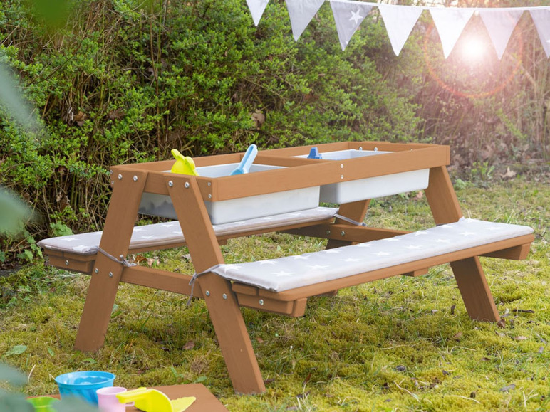 Ein hölzerner Picknicktisch mit zwei Bänken und zwei eingebauten Behältern für Sand und Wasser.