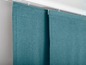Zwei türkisfarbene Vorhänge mit einer Schiene oben.