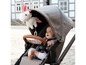 Ein Baby in einem grauen Kinderwagen mit einem Einhorn-Plüschtier