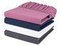 Ein Stapel Spannbettlaken in Rosa, Dunkelblau, Weiß und Grau.