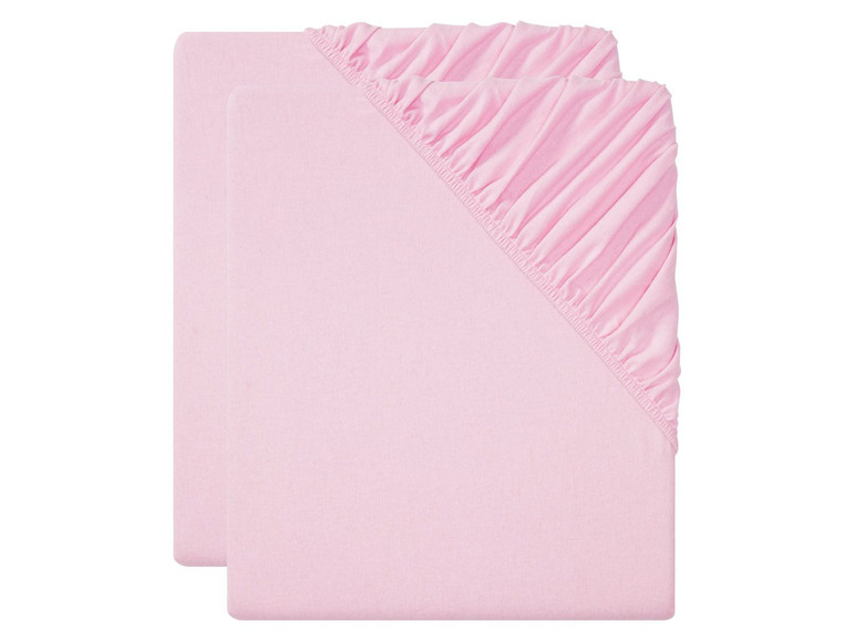 Zwei rosa Spannbettlaken für ein Babybett.