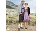 Ein Mann und eine Frau in traditioneller deutscher Tracht vor einer Berglandschaft.