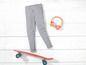 Graue Leggings, ein Skateboard und rosa Kopfhörer.