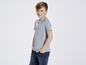 Ein Junge in einem blauen T-Shirt und Jeans.
