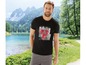 Mann in einem schwarzen T-Shirt mit geometrischem Muster vor einem Bergsee.