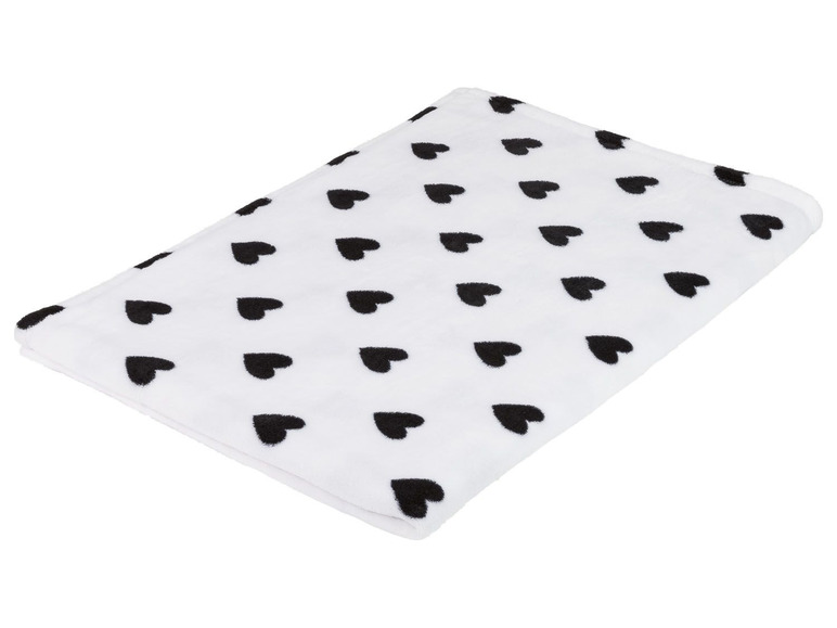 Eine weiße Decke mit schwarzen Herzen.
