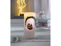 Eine weiße Kerze mit einem weihnachtlichen Motiv.