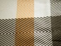 Beige, orange und schwarzes kariertes Textil.