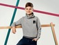Ein Junge trägt einen grauen Pullover mit einem 'skate'-Logo