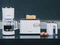 Eine weiße Kaffeemaschine, Toaster und Mixer von Grundig.