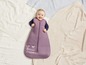 Ein Baby in einem lila Schlafsack mit dem Aufdruck 'Dance Dreams'.