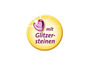Ein gelber Sticker mit einem pinken Herzen und dem Text 'mit Glitzersteinen'.