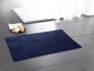 Eine dunkelblaue Badezimmermatte in einem Badezimmer.