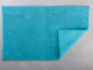 Türkisfarbene Badematte mit Noppenstruktur.