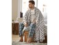 Mann mit Plaid-Decke, Schlafanzughose und bedrucktem T-Shirt.