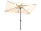 Ein beigefarbener Sonnenschirm mit schwarzem Metallmast.
