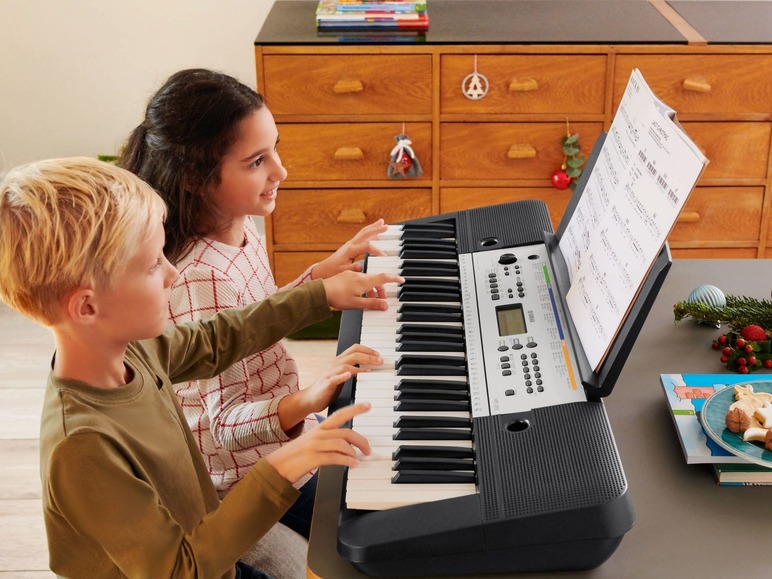 Zwei Kinder spielen auf einem Yamaha Keyboard.