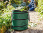 Ein grüner, zusammenklappbarer Abfalleimer im Garten.