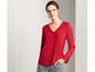 Eine Frau trägt eine rote Bluse mit langen Ärmeln.